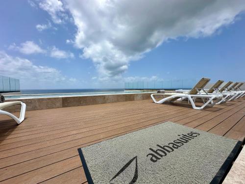 a deck with lounge chairs and a rug on the floor at abba Suites Playa del Carmen in Playa del Carmen