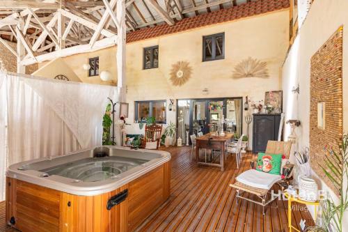 une grande chambre avec un jacuzzi dans l'établissement Douce Campagne Cottage Private Spa, à Blanc