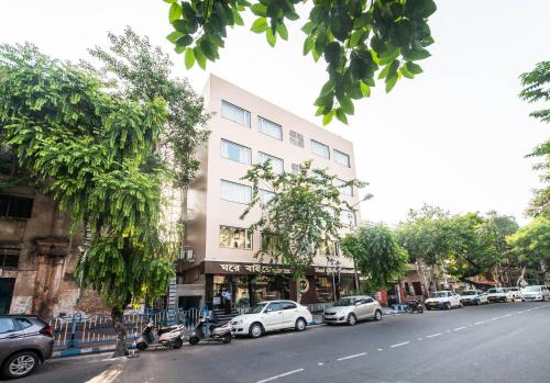 une rue avec des voitures garées devant un bâtiment dans l'établissement Treebo Trend Globe International, à Kolkata