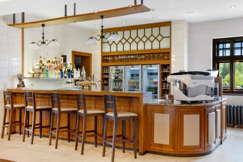 a bar in a restaurant with stools around it at Wellness Hotel Franz - Rejvíz in Jeseník