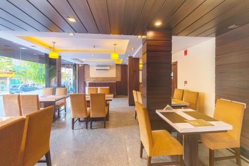 a restaurant with wooden walls and tables and chairs at Treebo Globe International Near Kalighat Mandir in Kolkata