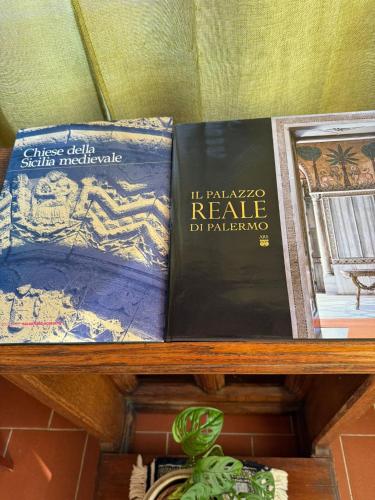 two books sitting on top of a wooden shelf at la Bellavita rooms in Caltanissetta
