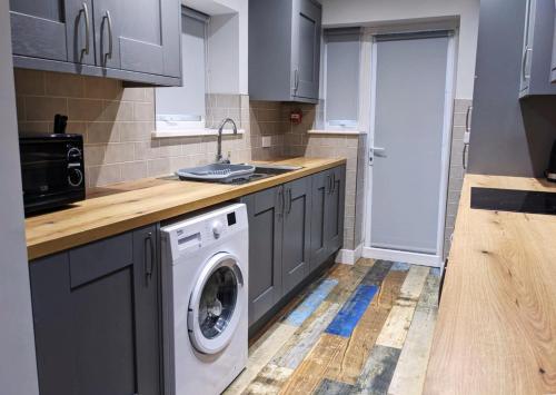 a kitchen with a washing machine and a sink at The Red Lounge Rooms Near Anfield in Liverpool