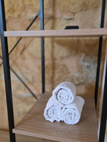 a white towel sitting on a wooden shelf at Amuri Holiday Home in Agrigento