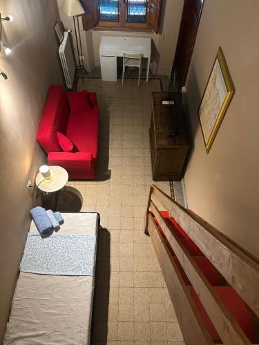 a living room with a red couch and a table at CASA BENVENUTI in Pisa