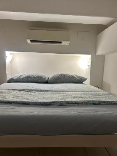 a bed with two pillows on top of it at CASA BENVENUTI in Pisa