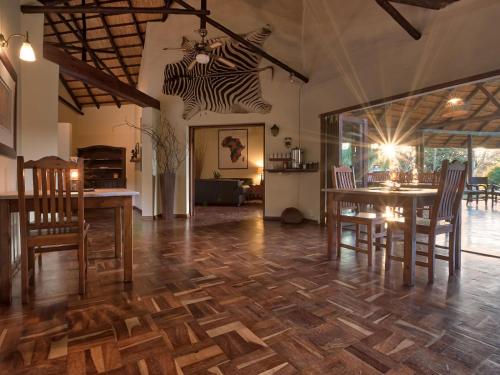 a dining room with a wooden floor and a table and chairs at Seringa Lodge & Safaris in White River