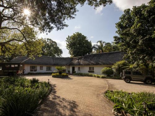 a house with a gambrel roof and a driveway at Seringa Lodge & Safaris in White River