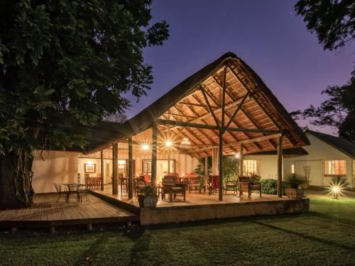 a house with a large wooden deck at night at Seringa Lodge & Safaris in White River