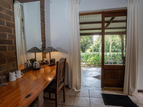 a dining room with a wooden table and a balcony at Seringa Lodge & Safaris in White River