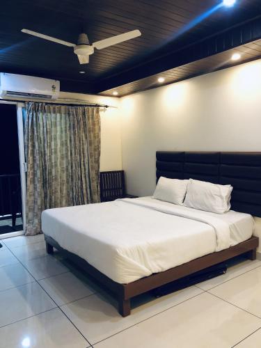 a bedroom with a large bed with a ceiling at Mountain river farm resort in Agali