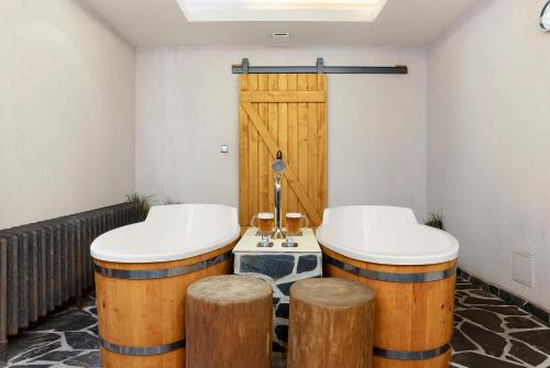 two large wooden stools in a bathroom with two sinks at Wellness Hotel Franz - Rejvíz in Jeseník