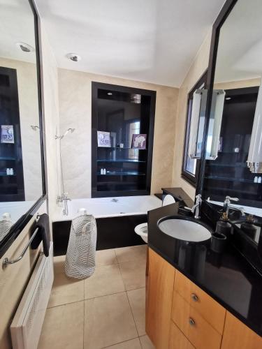 une salle de bain avec un lavabo et une baignoire dans l'établissement MONS 4 chambres vue panoramique sur la ville et ses environs climatisation parking intra muros, à Avignon