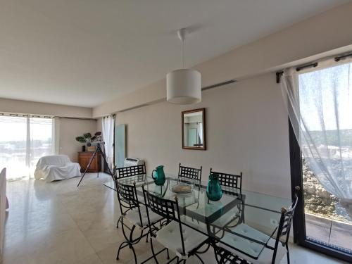 une salle à manger avec une table et des chaises en verre dans l'établissement MONS 4 chambres vue panoramique sur la ville et ses environs climatisation parking intra muros, à Avignon