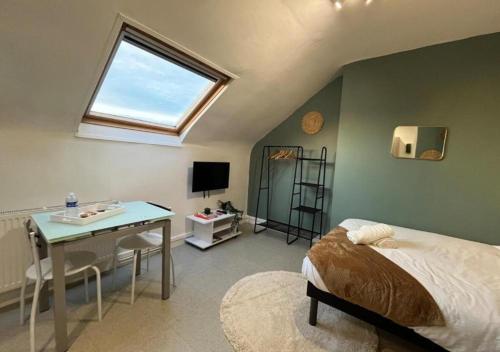 une chambre avec un lit, un bureau et une fenêtre dans l'établissement Le Verdélite - Studio design & végétal proche gare, à Évreux