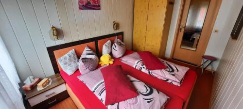 a bedroom with a red bed with pillows at Haus-Dannigkow in Dannigkow