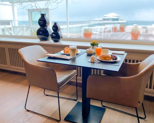 a table with breakfast food on it in a restaurant at Grand Hotel Seeschlösschen Sea Retreat & SPA in Timmendorfer Strand