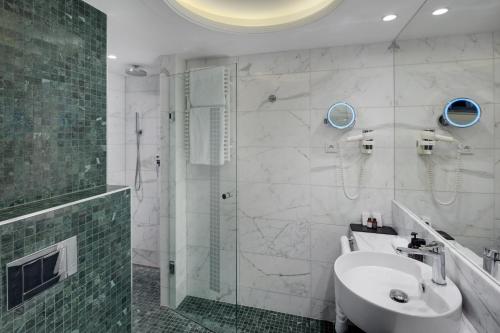 a bathroom with a glass shower and a sink at Hotel Savoy Prague in Prague