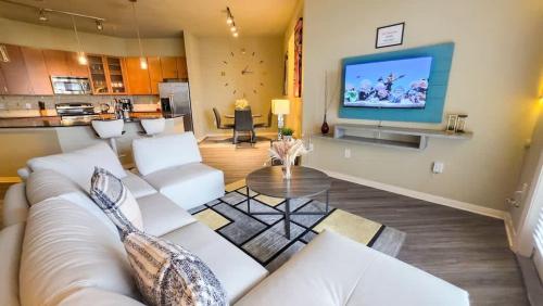 a living room with a couch and a tv at Galleria Luxury Stay Pool Gym Stunning Views in Houston