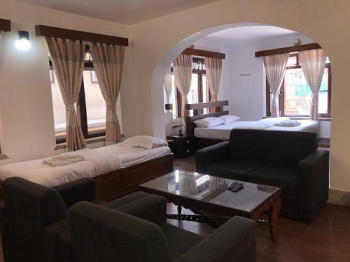 a hotel room with two beds and a couch and a table at Apartment in Nepal in Kathmandu