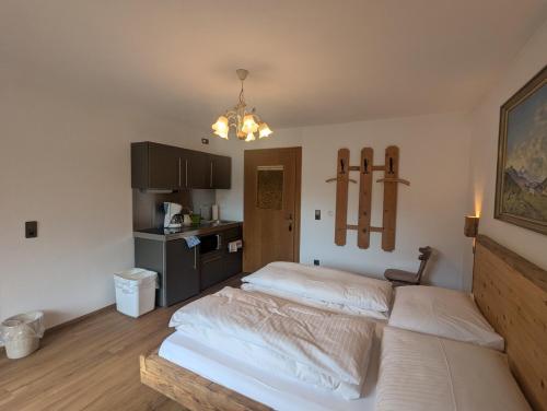 a bedroom with two beds and a kitchen at Bergfreund in Lermoos