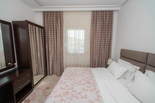 a hotel room with a bed and a television at The One Boutique Hotel in Muçaj