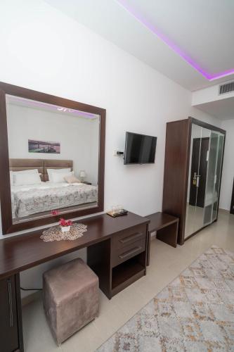 a bedroom with a large mirror on the wall at The One Boutique Hotel in Muçaj