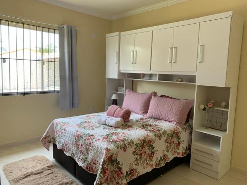 a bedroom with a bed with a teddy bear on it at Vila Sunset Saquarema RJ in Saquarema