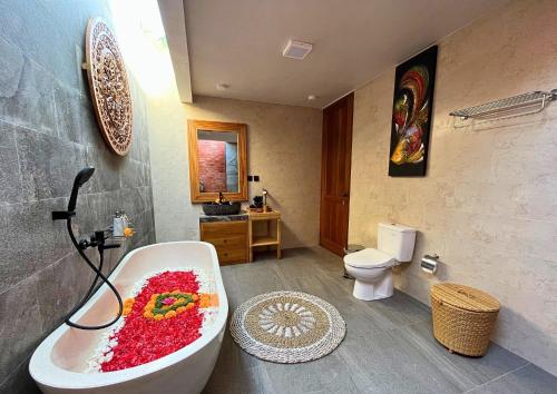 a bathroom with a bath tub filled with red flowers at Maharatu Suite Villa in Ubud