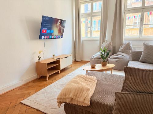a living room with a couch and a tv on the wall at DREAMZzz AltstadtTraum im Herzen Coburgs Parkplatz in Coburg