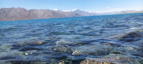 a large body of water with mountains in the background at Pangong Destination in Spangmik