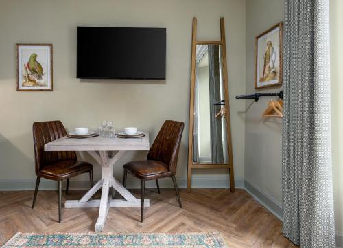 a dining room with a table and chairs and a television at Munro Guest House in Stirling