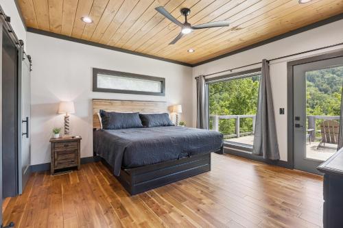 ein Schlafzimmer mit einem Bett und einem Deckenventilator in der Unterkunft Sunscape Villa – Luxury Gatlinburg Cabin with Hot Tub, Game Room & Breathtaking City Views in Gatlinburg