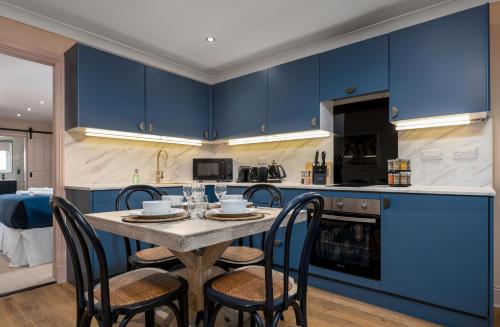 a kitchen with blue cabinets and a table with chairs at Munro Guest House in Stirling