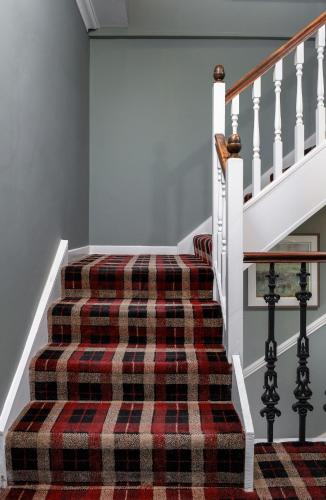 a staircase with a plaid rug on the stairs at Munro Guest House in Stirling