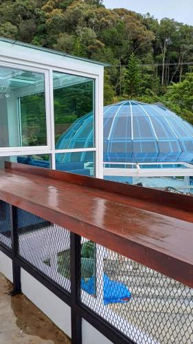 a bench on a house with a view of a dome at Sling & Stone Mountain Suites in Kundasang