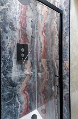 a shower with a glass shower stall with a shower head at Munro Guest House in Stirling