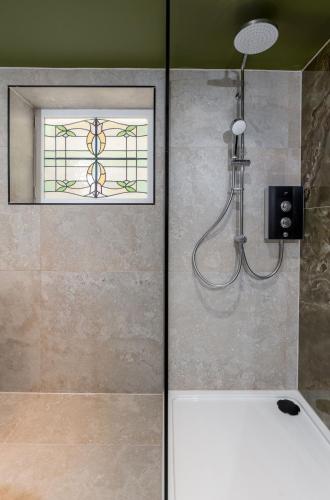 a shower in a bathroom with a window at Munro Guest House in Stirling