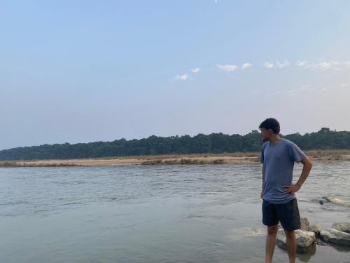 a man standing on the shore of a body of water at Homestay and Trip Organiser in Bākhri Kharka