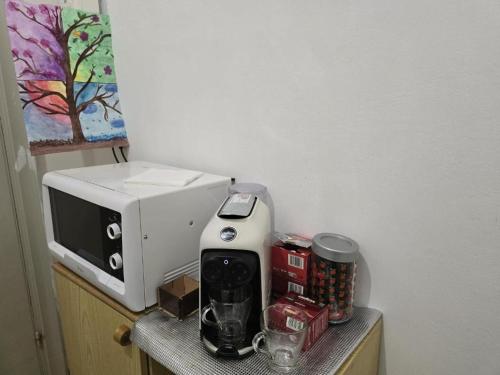 a coffee maker and a microwave on a table at Room PR Casa Solari in Genova