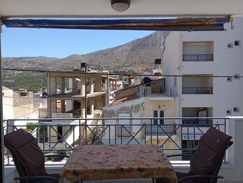 a table and chairs on a balcony with a view at Διαμέρισμα δυο υπνοδωματίων in Neápolis