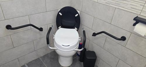 a bathroom with a white toilet with a black lid at Accesible countryside retreat with private garden and all modern facilities in Chassenon