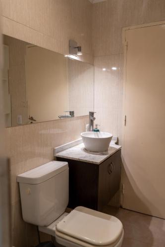 a bathroom with a white toilet and a sink at Alma departamentos de mar 2 in Ostende