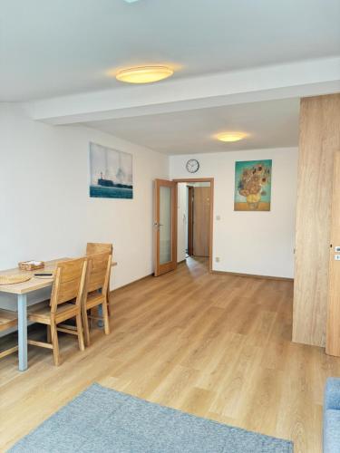 a dining room and living room with a table and chairs at Riverside Apartment Praha in Prague