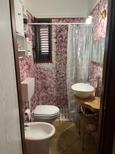 a bathroom with a toilet and a sink at Villa Rosa in Alessano