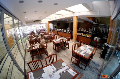 an overhead view of a restaurant with tables and chairs at Actuall Convention by Summit Hotels in Contagem