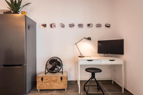 a room with a desk with a television and a stool at "Sun down" by Corralejobeach Apartments in Corralejo