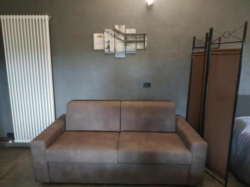 a brown leather couch in a room with a bed at Casa Piemontese in Mango