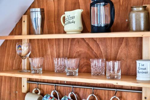 a wooden shelf with glasses on it at Green Gables by Escape Ordinary in Aghnablaney
