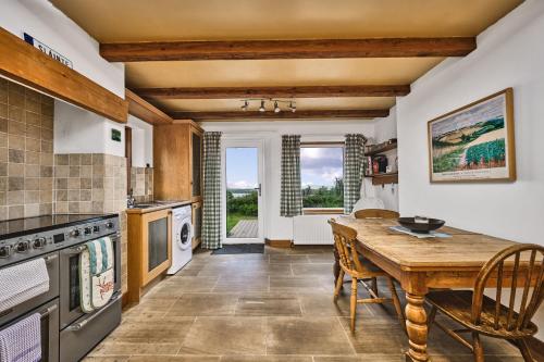 a kitchen with a wooden table and a dining room at Green Gables by Escape Ordinary in Aghnablaney